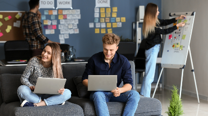 Drei Studenten auf Sofa mit Laptop