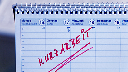 Tischkalender mit roter Schrift das Wort Kurzarbeit