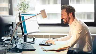 Mann arbeitet am PC mit der Lohnabrechnung edlohn